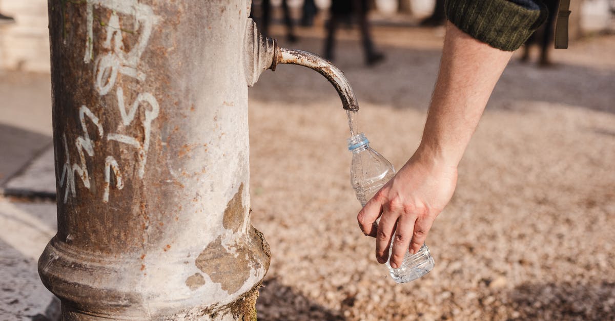 Could plastic or metal cans damage my oven? - Crop person filling bottle with water from drinking fountain