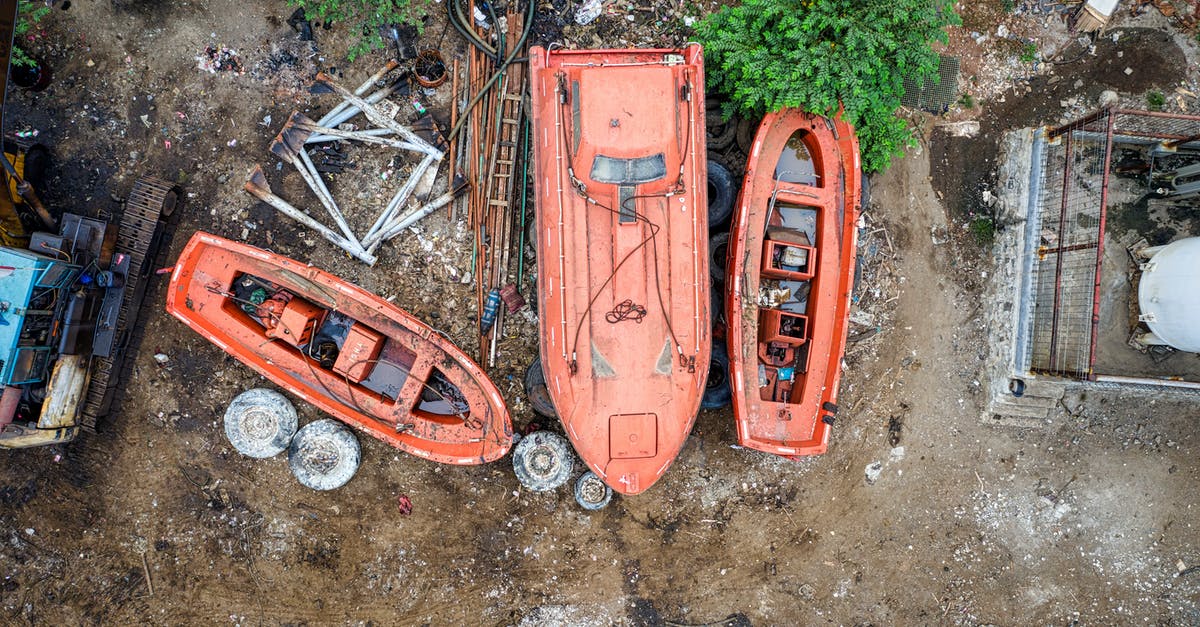 Could plastic or metal cans damage my oven? - Top view of aged orange boats placed on dirty ground in countryside in daylight