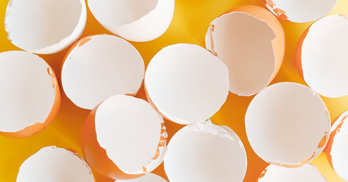 Cracking an egg - Broken Eggshells on a Yellow Background