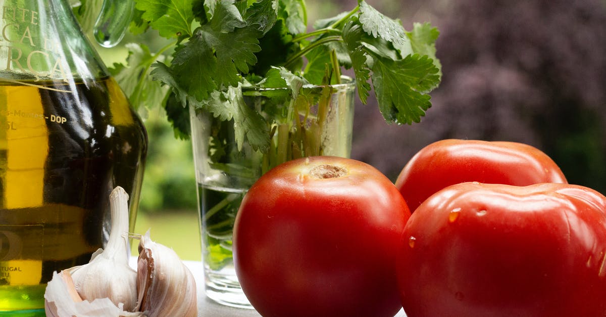 Cream of Tomato with garlic + cilantro stalks aroma - Tomatoes with garlic cloves near fresh parsley and oil