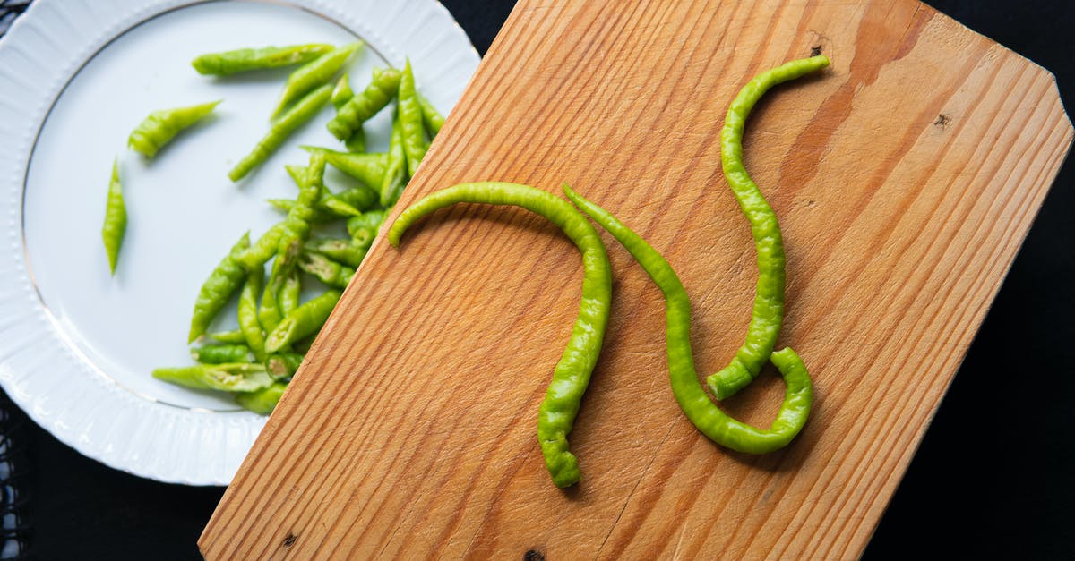 Create hot "sauce" from capsaicin extract - Green hot pepper on cutting board and plate