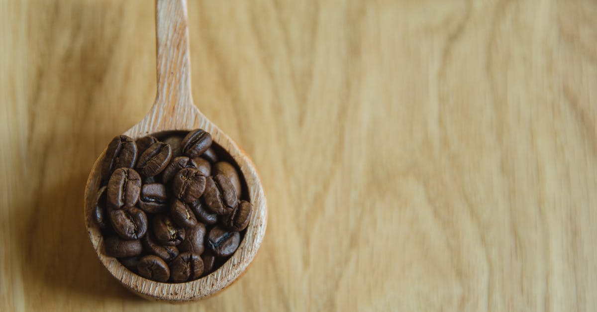 crispy Dilly beans - Top view of wooden cup full of coffee beans located on wooden table