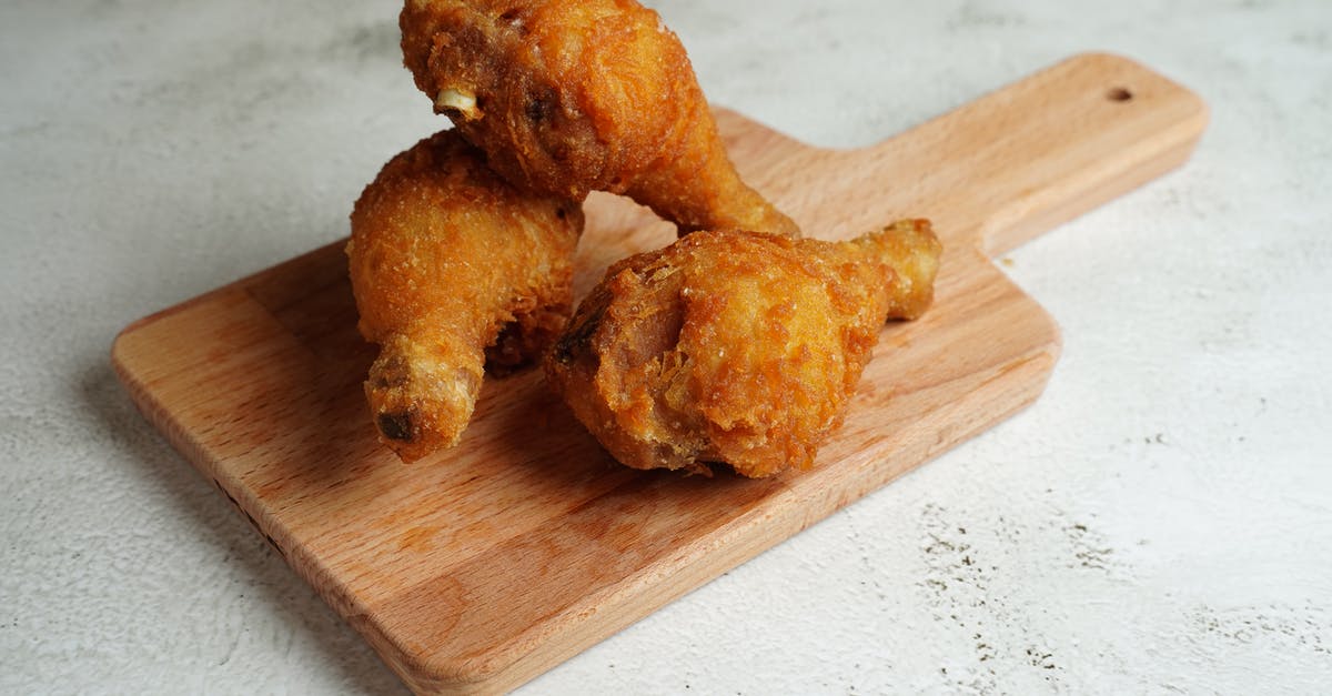 Crispy fried chicken goes limp: picnic disaster - From above of plastic container with fried chicken and rice with sauce near sauce and sliced vegetables