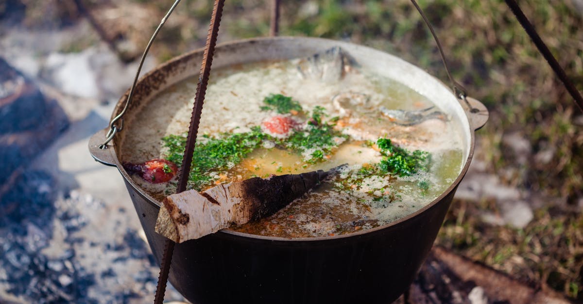 Crock Pot to Enameled Cast Iron Pot Cooking Times and Temperatures - Birch firewood in ukha with aromatic broth and cut fresh herbs in cast iron pot outdoors