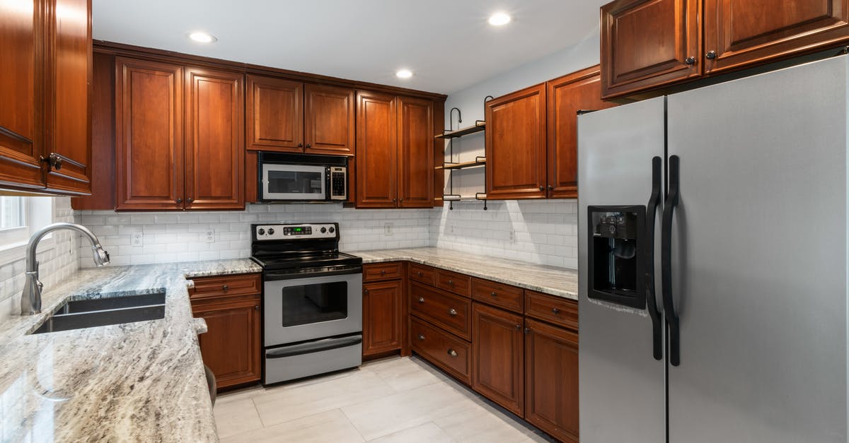 Crowding loaves in deck oven - Black and Silver Microwave Oven on Brown Wooden Kitchen Cabinet