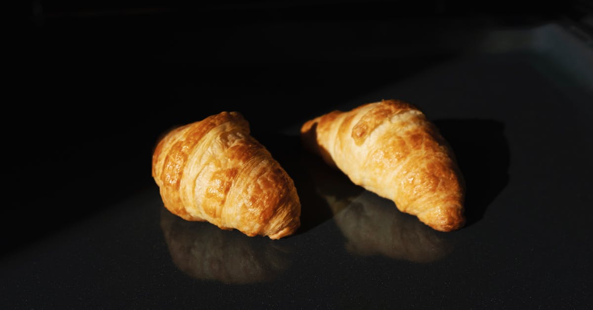 Crusty french bread - Pair of fresh yummy croissants on black glass surface