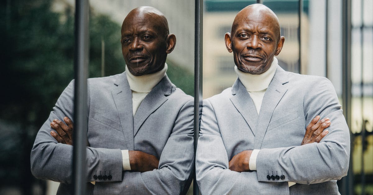 Cues to a reliable or unreliable recipe? - Serious black businessman leaning on glass wall