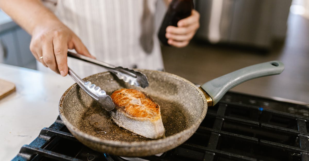 Culinary purpose of frying pan foil sheet for cooking fish? (not wrapped in foil) - Unrecognizable Chef Preparing Fish Slice on Frying Pan