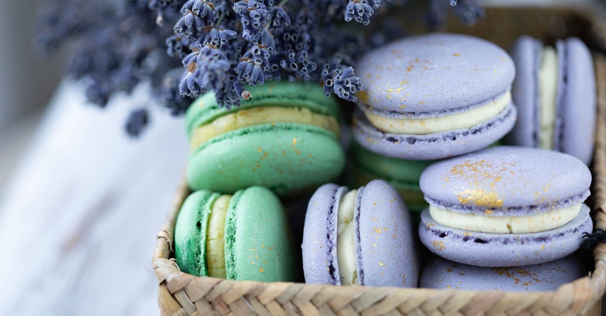 Culinary uses for lavender - Heap of many tasty sweet macaroons under blooming gentle lavender on blurred background