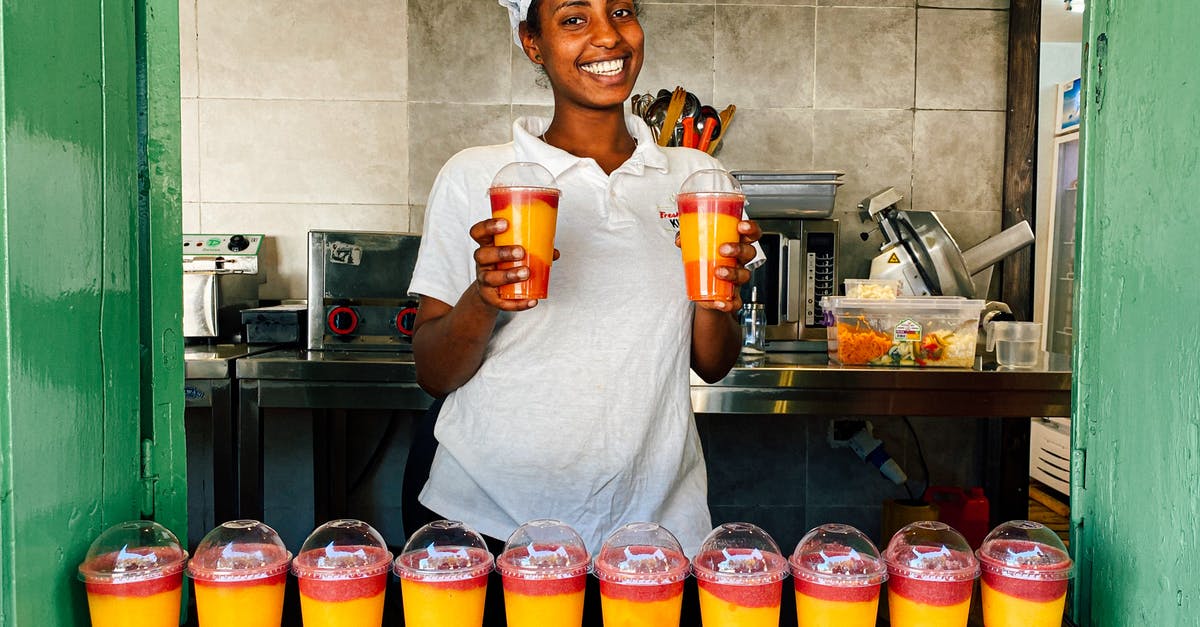 Cup measurements: shake or scrape? - Woman in White Polo Shirt Holding Multicolored Shake in Plastic Cups