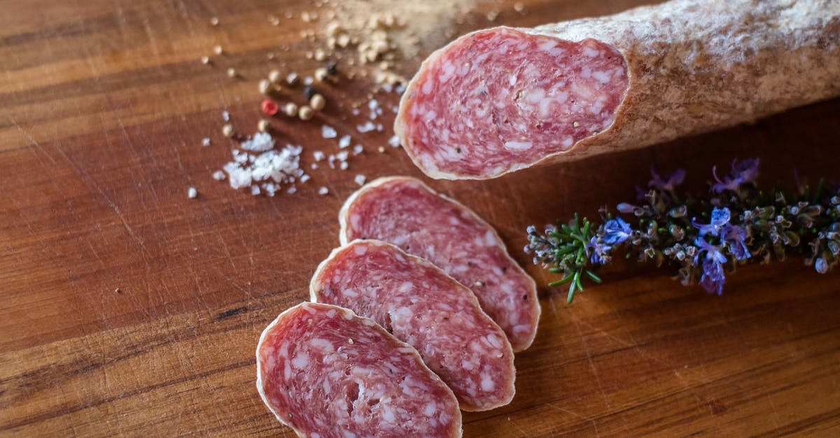 Curing with smoked salt - Delicious salami slices near spices and rosemary