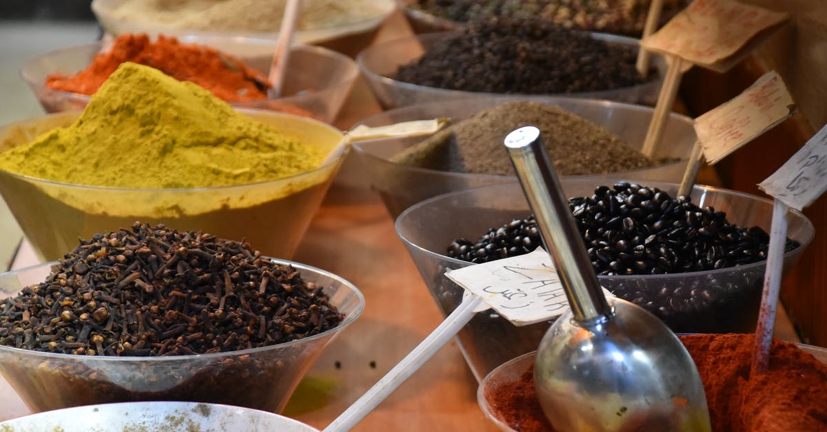 Curry powder mix - From above of bowls full of various dry seasonings on table in street bazaar