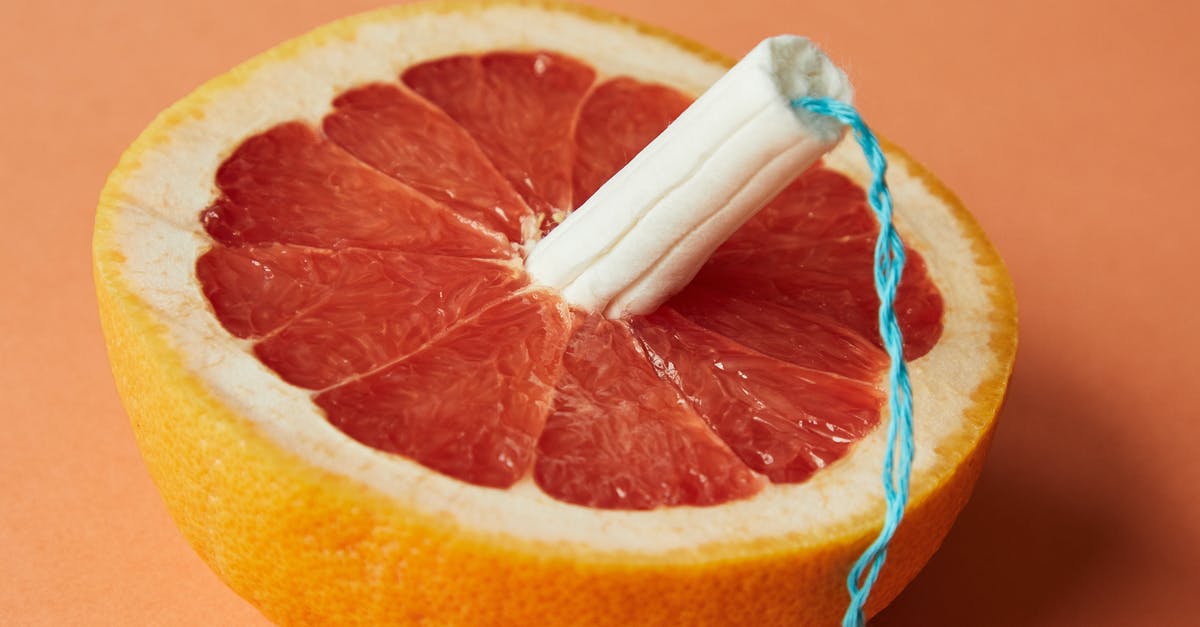 Custard surface has tiny pockmarks when I use fruit pulp - From above of half of sliced ripe grapefruit with tampon in center showing use of feminine product during menstruation