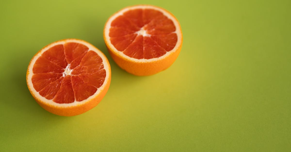 data about the rate of nutrient decay in fruit/vegetable juice [closed] - Tasty ripe citrus fruit with juicy pulp cut in half placed together on bright green surface