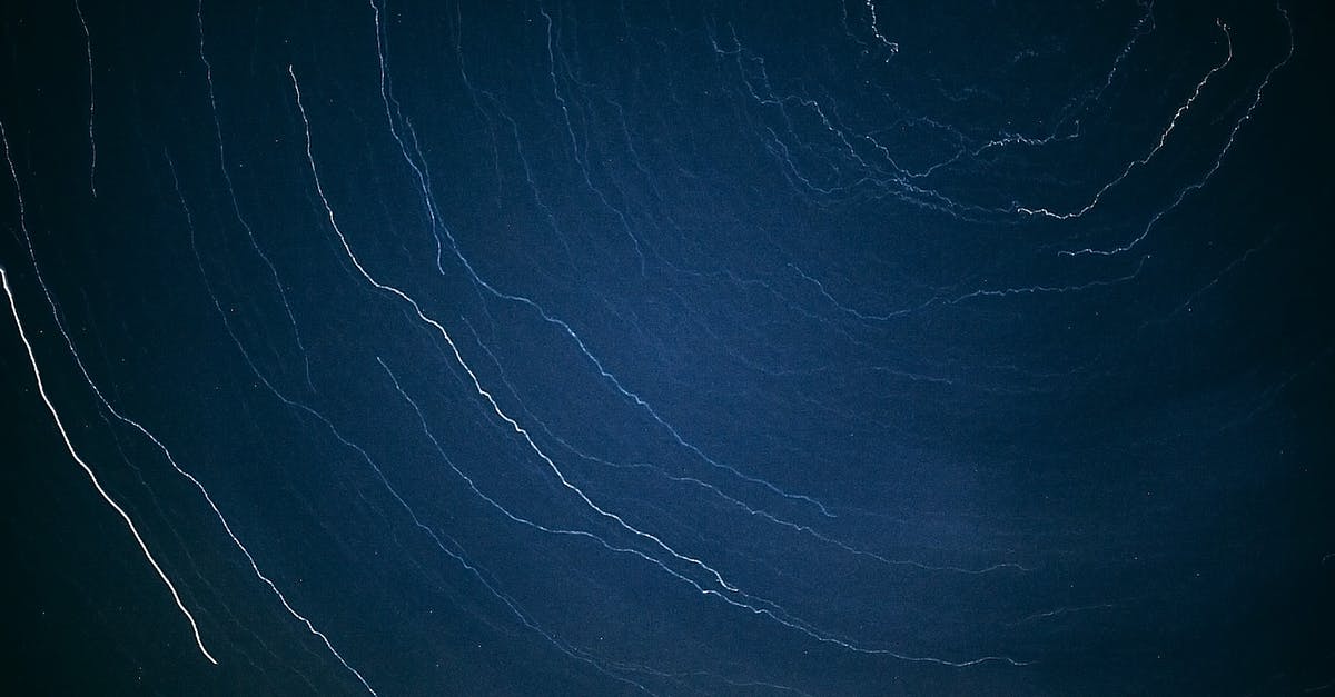 Date cookies are thin and spread out - Abstract backdrop of white wavy thin lines in row on dark blue surface