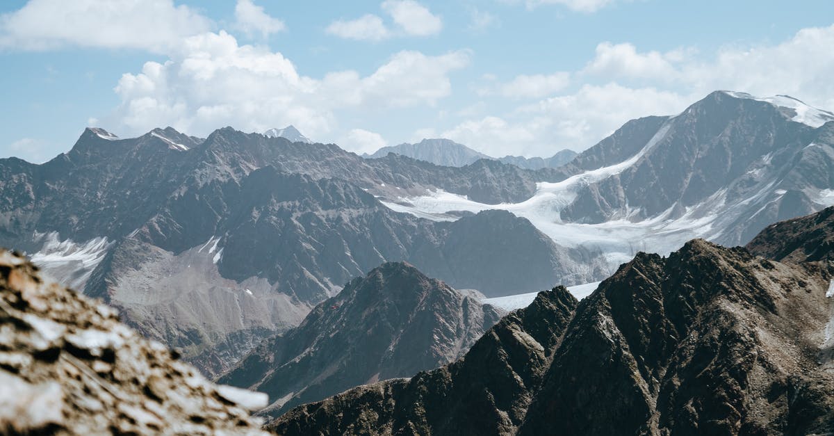 Dealing with frozen ground beef - Picturesque scenery of rough rocky mountain tops covered with snow located highland under cloudy sky