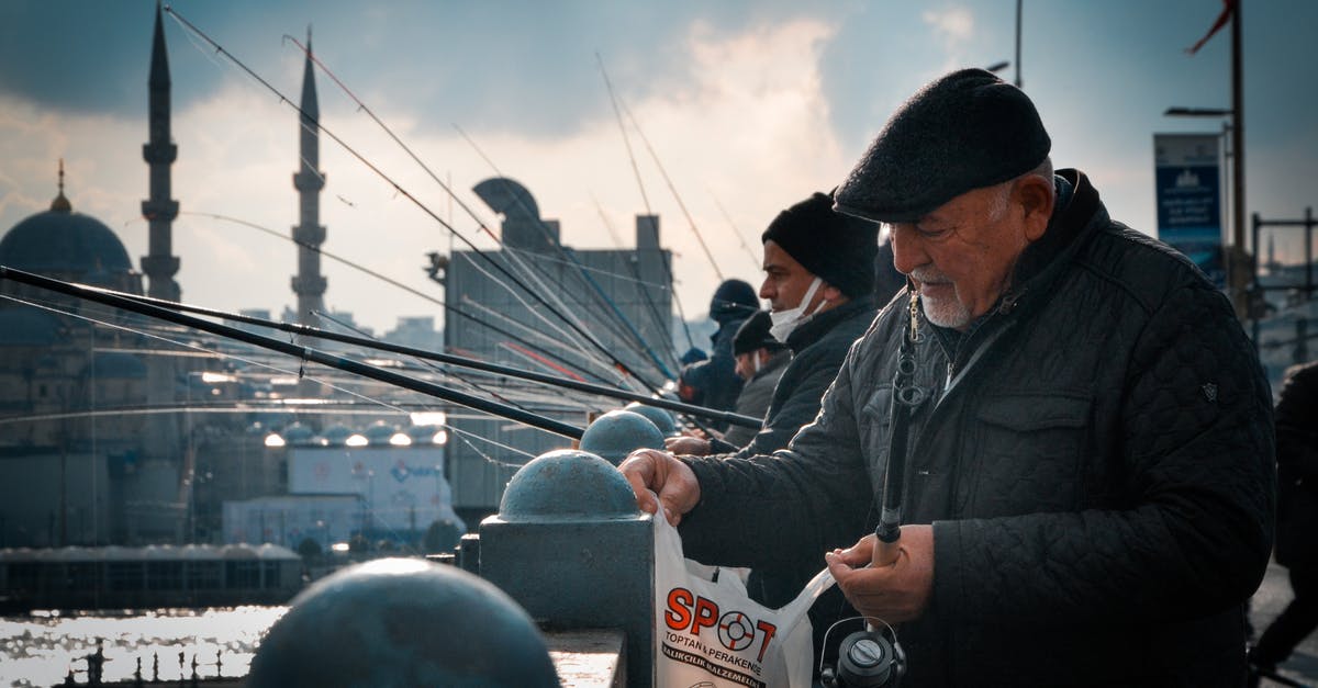 Defrosting Fish without Bag - Men Fishing on Bridge in City with Mosque in Background