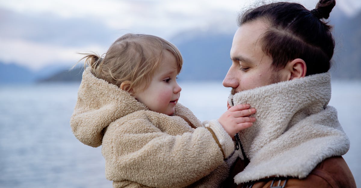 Defrosting meat/fish in warm water - Satisfied young father and little daughter near sea in cold season