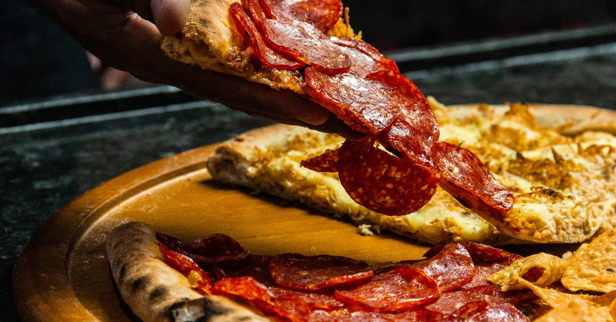 Defrosting pizza dough correctly? - Photo Of Person Holding Sliced Pizza