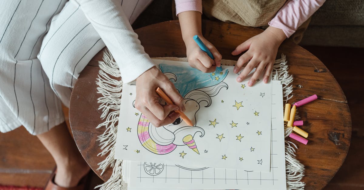 Dehydrating Strawberries - Wax Paper or Parchment? - From above of crop unrecognizable mother and daughter using wax pencils for coloring drawing with unicorn on coffee table at home