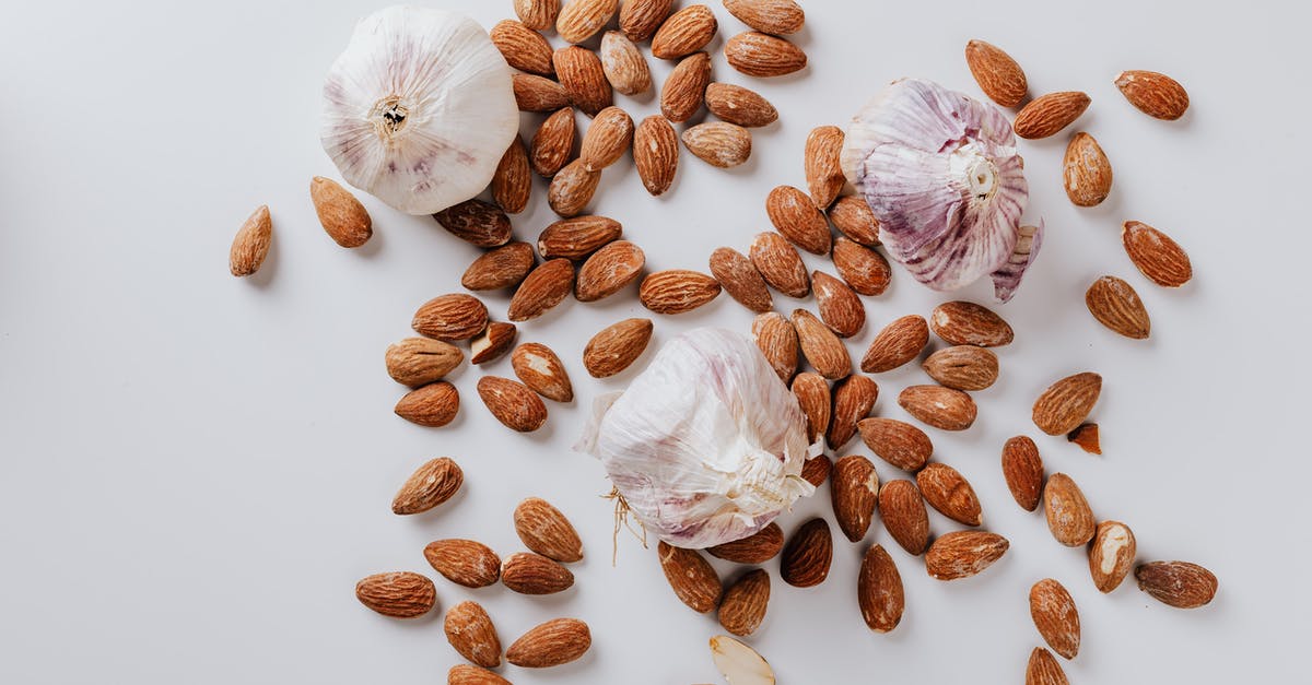 Devil's food cake turned out dry and dense - Raw almonds and heads of garlic on white background