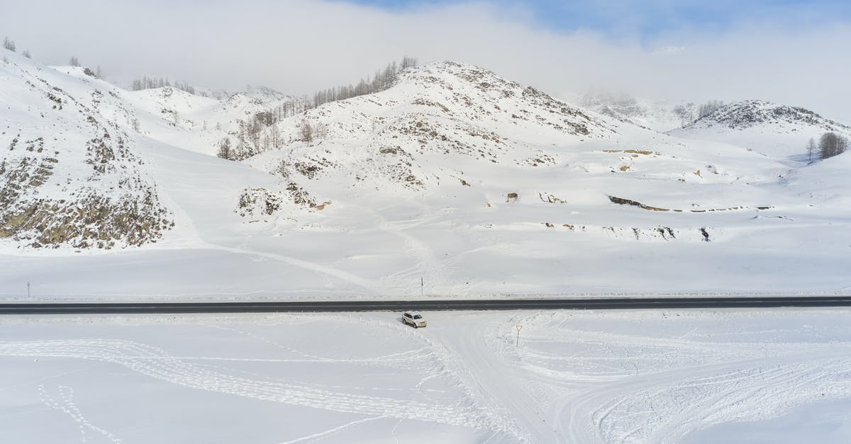 Did I turn my frosting into mayonnaise? - Modern car riding along road against snowy hills