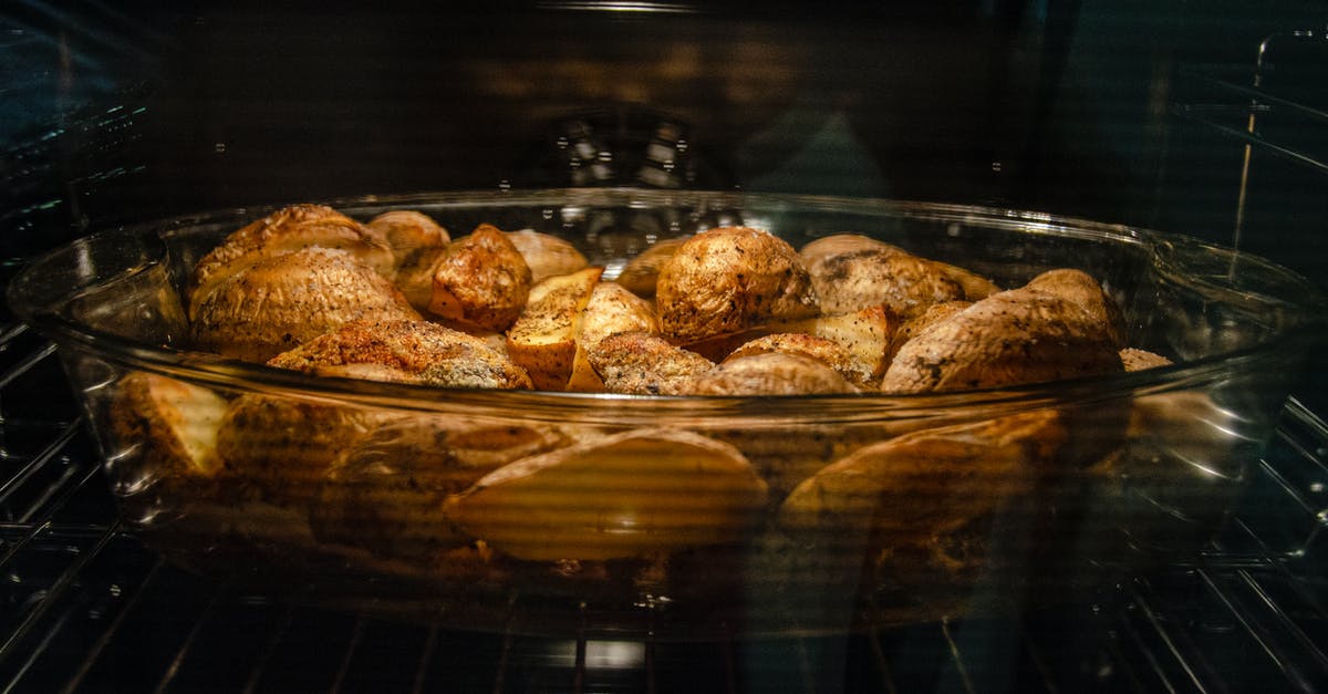 Difference between bake and roast - Delicious spicy potatoes in glass dish in oven