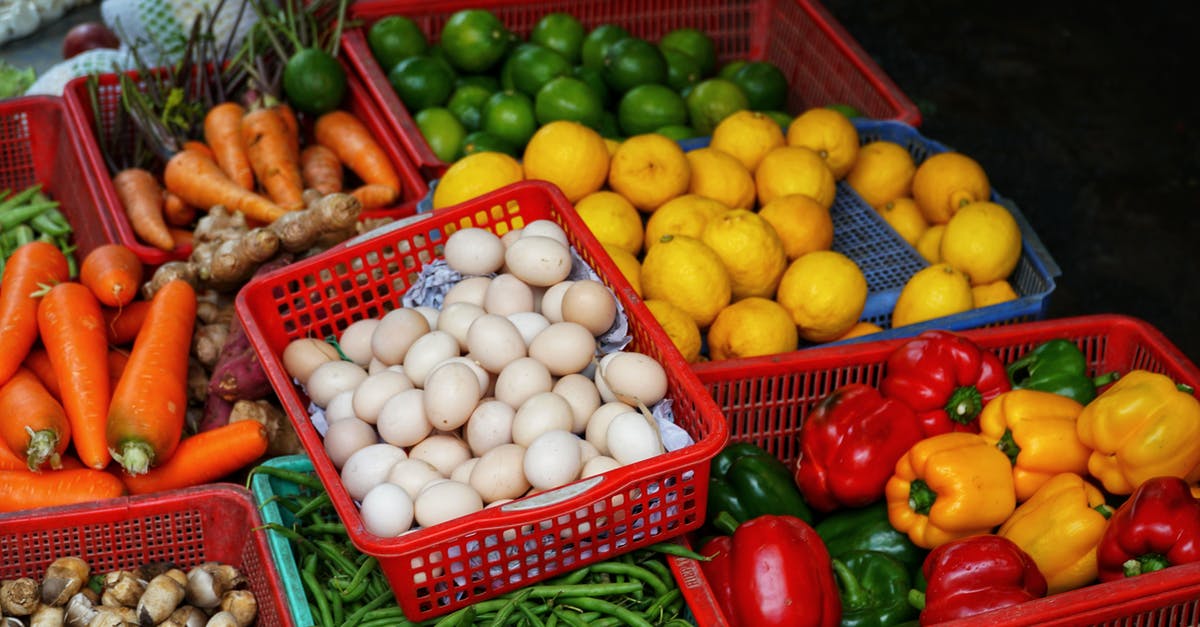 Difference between chicken and duck eggs? - From above of collection of colorful ripe vegetables and citrus fruits in plastic boxes in street market