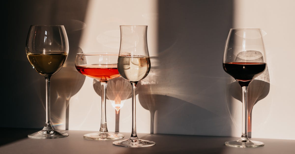 Difference between Spumante & Champagne - Different sorts of wine in various glasses on table in sunlight