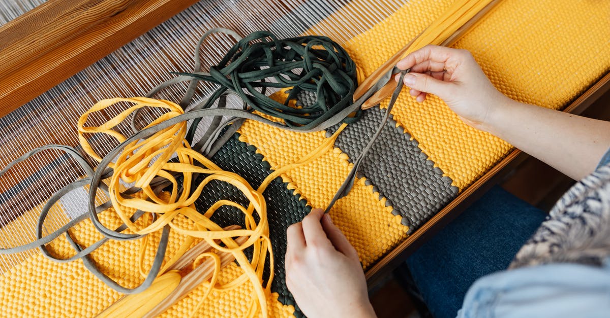 Difference between yellow and gray bacalao (salted cod)? - Top view of crop anonymous female employee working on wooden weaving loom machine with stretched durable colorful threads in workshop