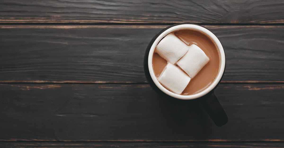 Dissolving cocoa in liquid [duplicate] - From above mug of delicious aromatic cocoa with marshmallows served on wooden table