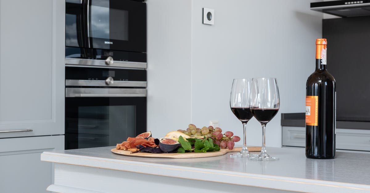 Distribution of heat using a silicone oven tray - Wineglasses near fruits on counter