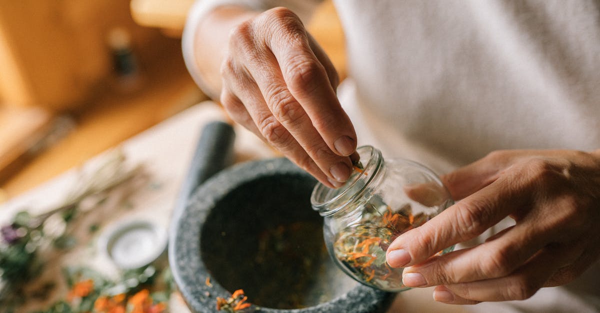 DIY herb preservation - A Person Holding a Glass Container