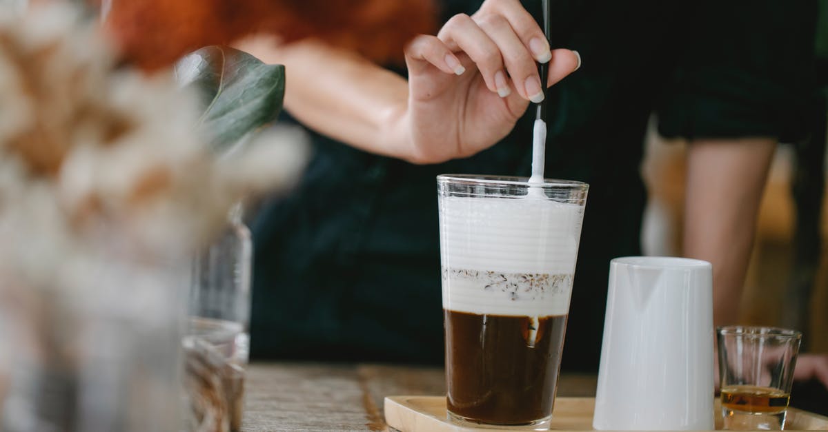 Do all varieties of cocoa naturally taste bitter? - Crop unrecognizable woman putting straw in glass of iced latte