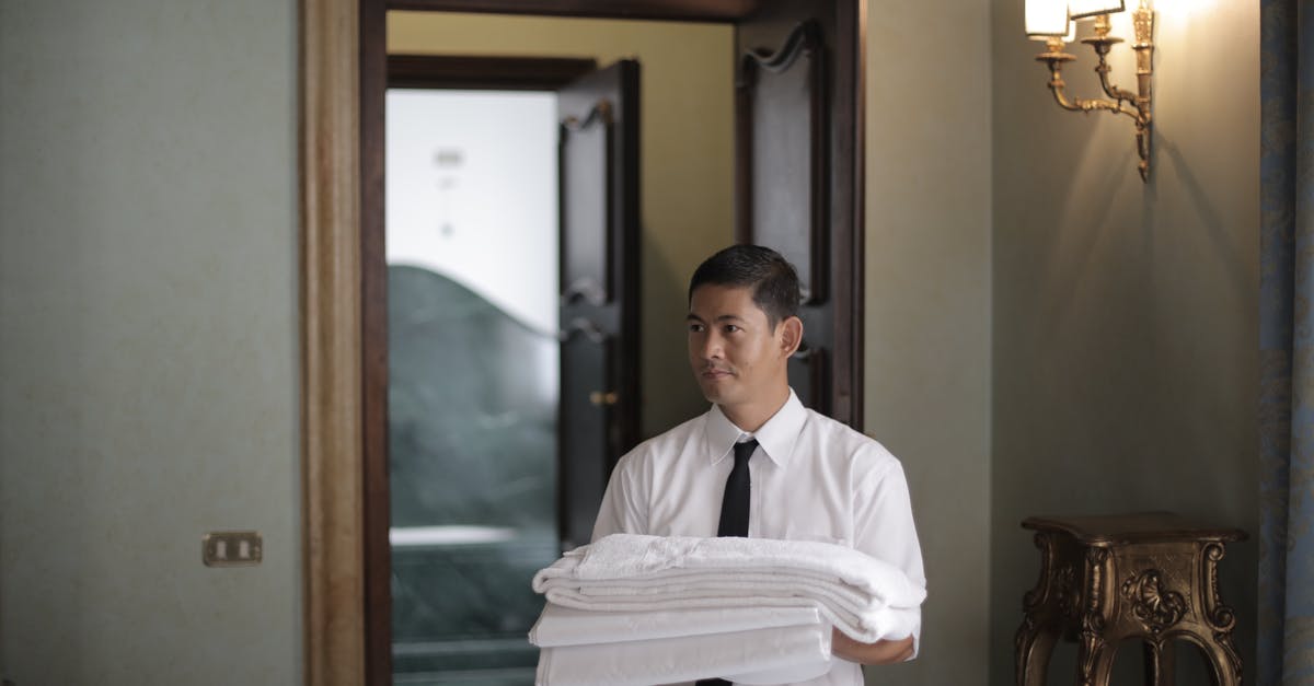 Do Asian groceries carry vital wheat gluten? - Young male housekeeper carrying stack of white bed sheets while entering bedroom in hotel