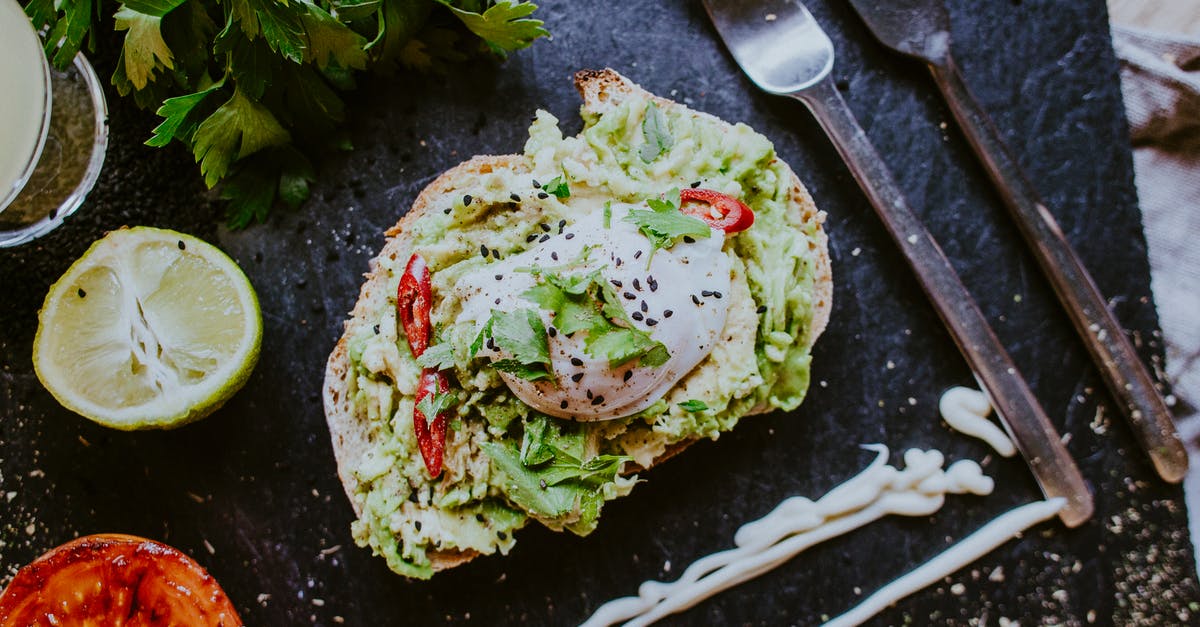 Do cooled-down/chilled toasted black sesame seeds taste nearly raw again? - From above of yummy crispy toast with lettuce leaves and poached egg decorated with chili pepper slices and sesame seeds on plate with grilled tomato and mayo sauce