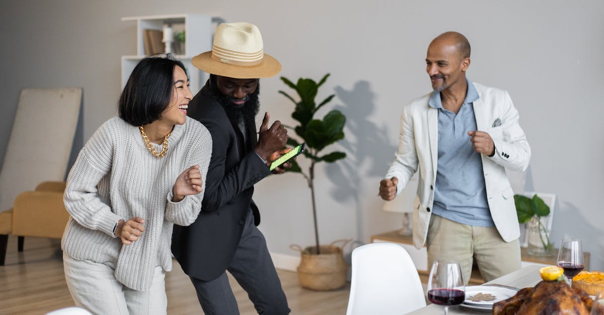 Do I have to tie my turkey legs together? - Positive diverse friends dancing while celebrating Thanksgiving