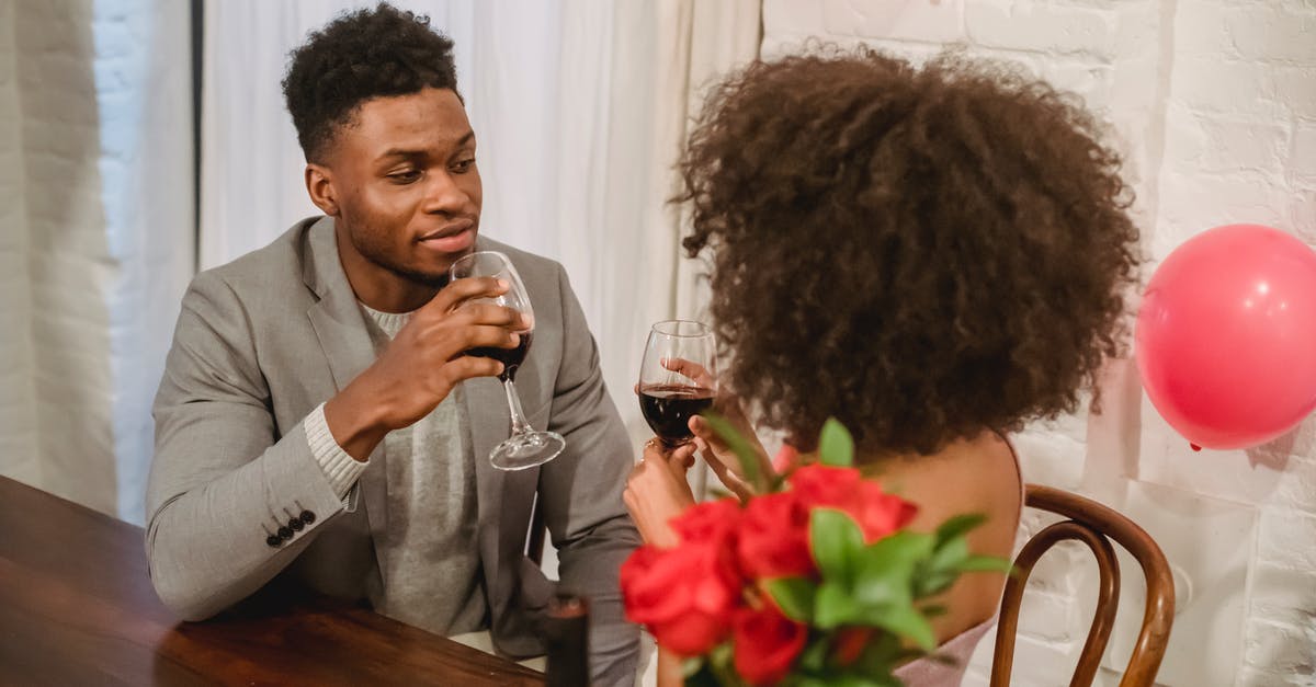 Do I need to let red wine breathe each time I uncork the same bottle? - Young black couple in elegant clothes sitting at table while drinking wine from glasses near bottle and vase with flowers bouquet in loft with balloons while looking at each other Do I need to let red wine breathe each time I uncork the same bottle? - Young black couple in elegant clothes sitting at table while drinking wine from glasses near bottle and vase with flowers bouquet in loft with balloons while looking at each other
