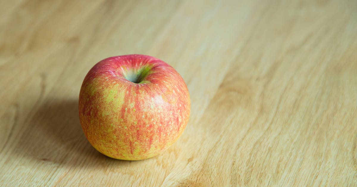 Do I need to peel a red kuri squash? - From above of delicious whole juicy apple with red and yellow peel on desk