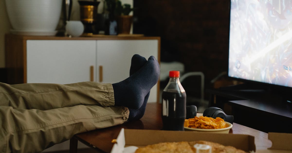 Do pies baked in disposable pans turn out okay? - Crop person with crossed legs on table against monitor