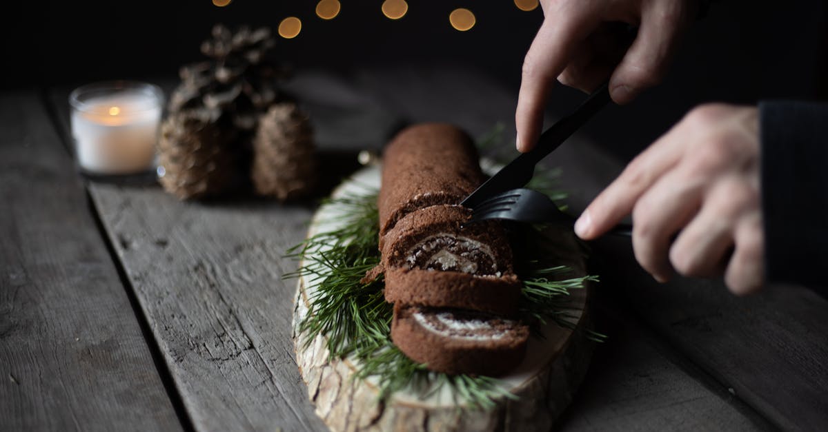 Do plastic cutting boards dull knives faster than wood boards? - Person Slicing a Brown Chocolate Swiss Roll Cake