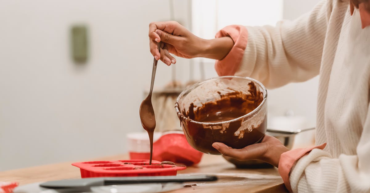 Do silicone baking mats come in 14x16" sizes? - Crop anonymous African American female pouring sweet tasty melted chocolate in red silicone baking dish