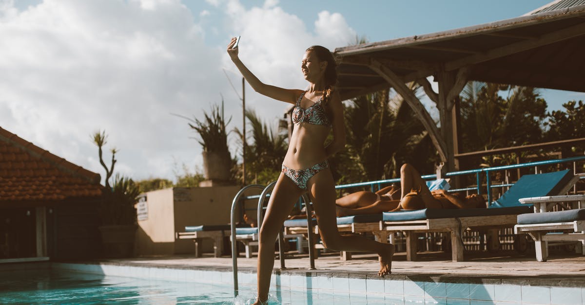 Do you have to use water to sous vide? - Full body cheerful slim female in swimwear taking selfie on cellphone while jumping into swimming pool in resort on sunny day