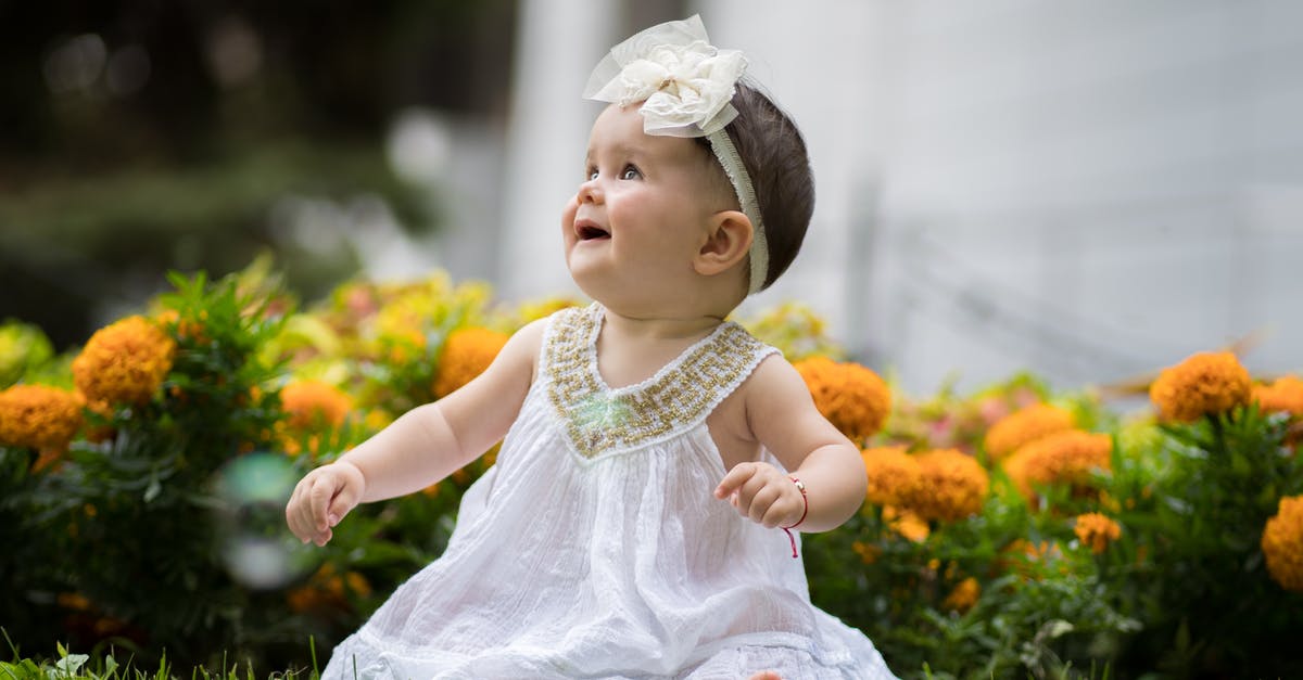 Does 100% pure honey expire? - Little Baby Girl Sitting on Grass in a White Dress and Smiling 
