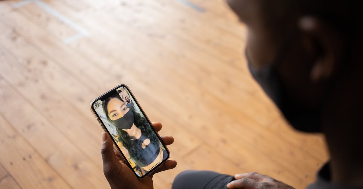 Does a splatter screen prevent grease build up in kitchen? - Crop black man talking to girlfriend in mask on smartphone