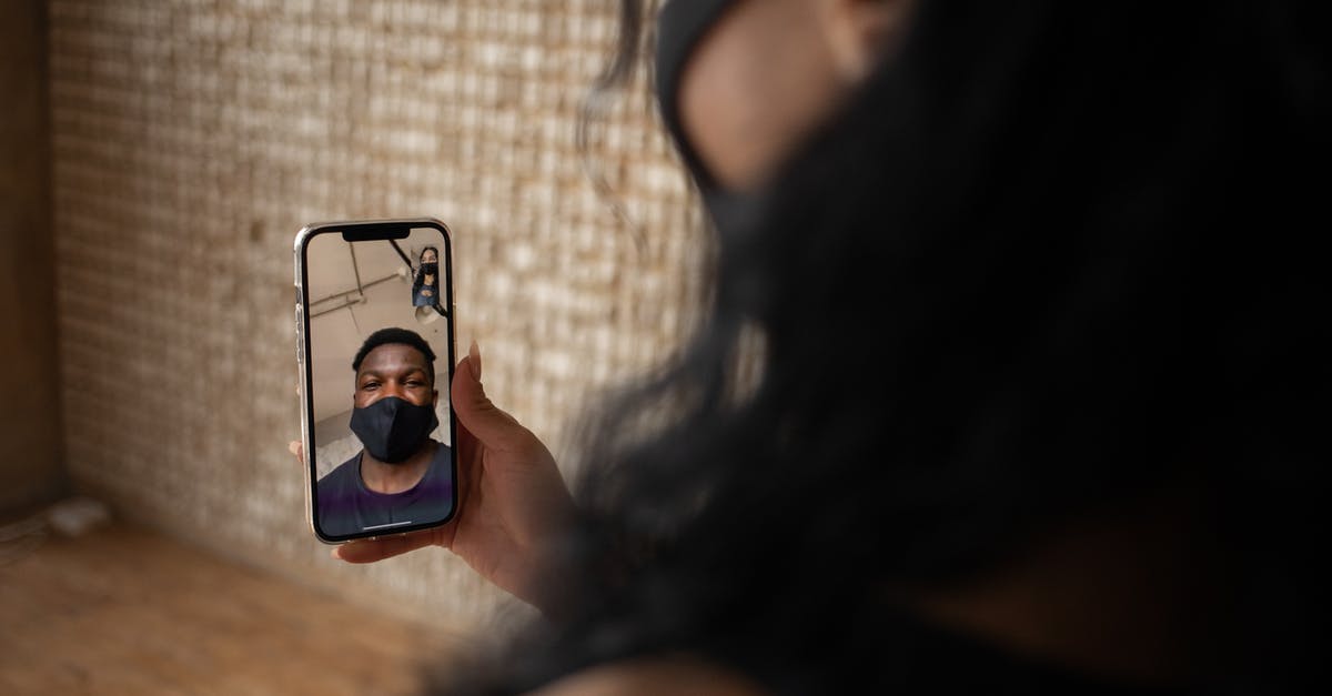 Does a splatter screen prevent grease build up in kitchen? - Back view of crop anonymous female talking to ethnic male beloved in fabric mask during video call on cellphone