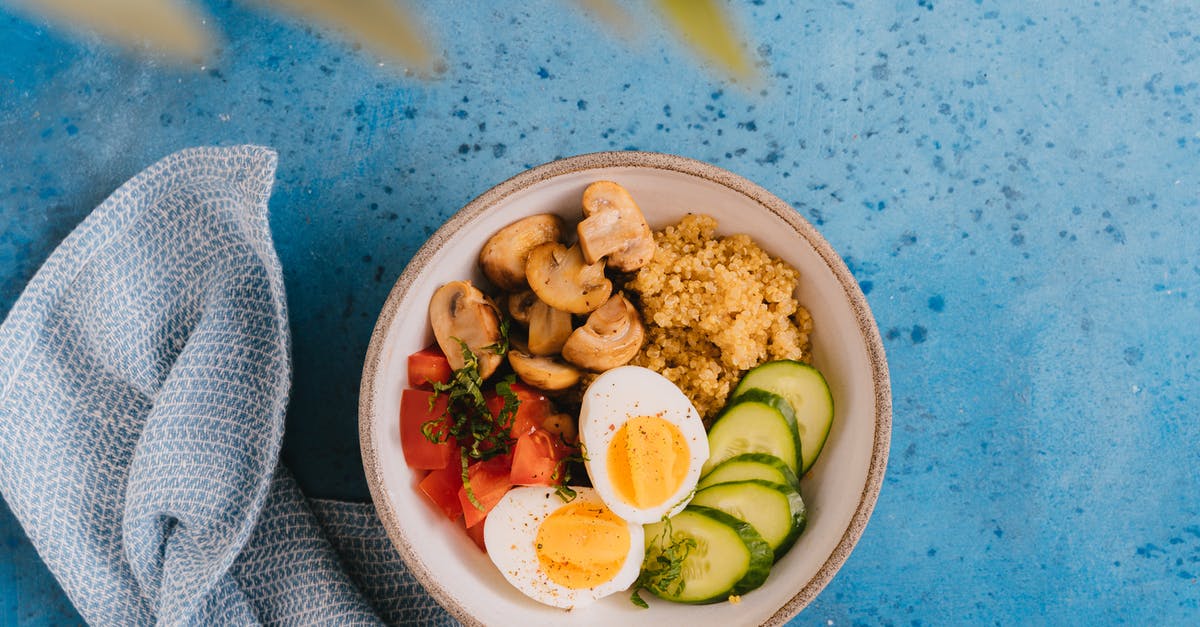 Does adding vinegar to rice while while boiling reduce stickyness or improve hardness? - A Bowl of Food over Blue Surface