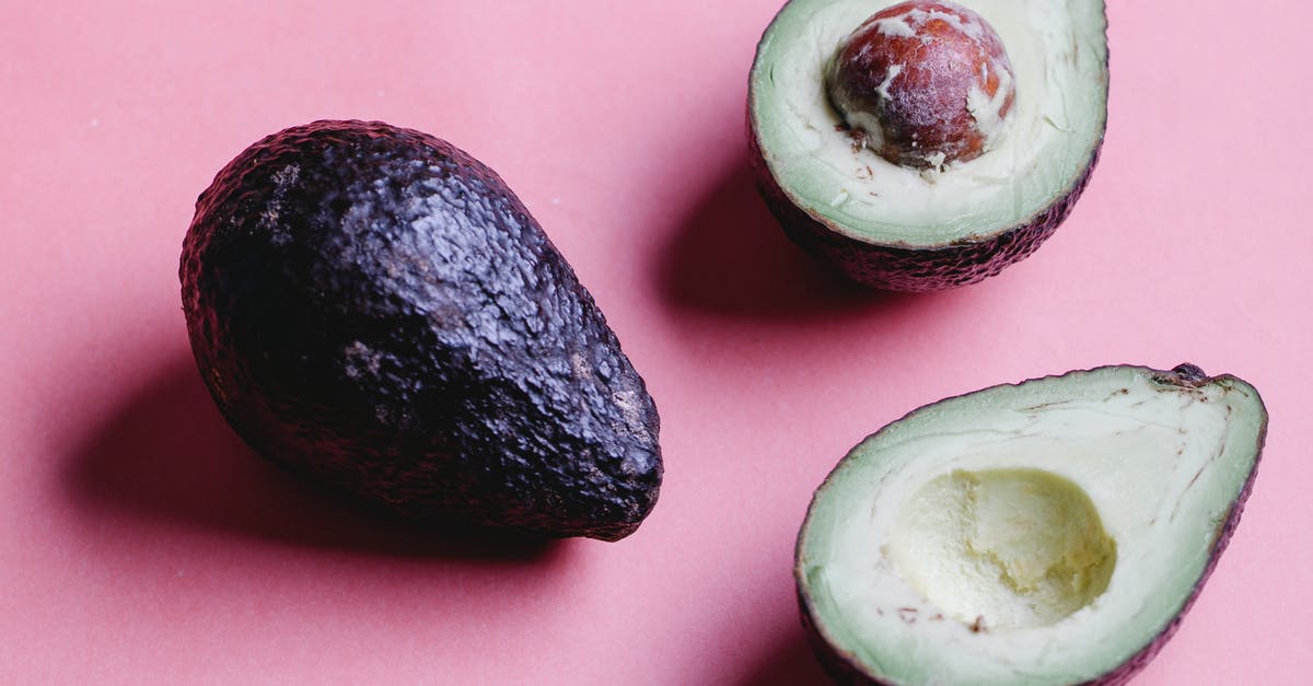 Does an avocado seed help guacamole stay green? - Composition of halved avocados on pink background