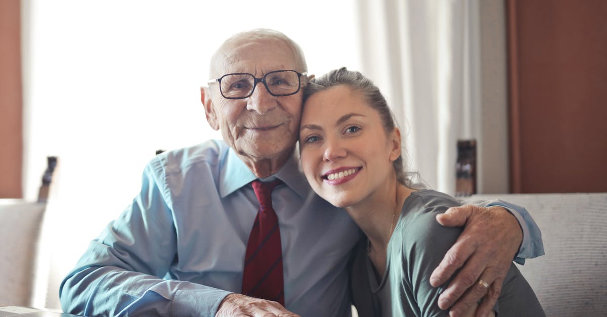 Does anyone know what kind of pan this is? - Positive senior man in formal wear and eyeglasses hugging with young lady while sitting at table