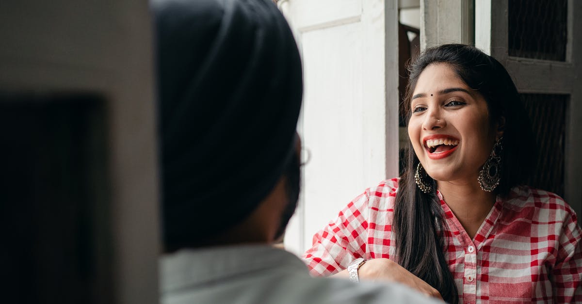 Does authentic Italian tiramisu contain large amounts of espresso? - Excited young attractive female with bindi on forehead wearing large earrings with authentic design and checkered cloth sitting in doorway with blurred husband wearing turban during free time